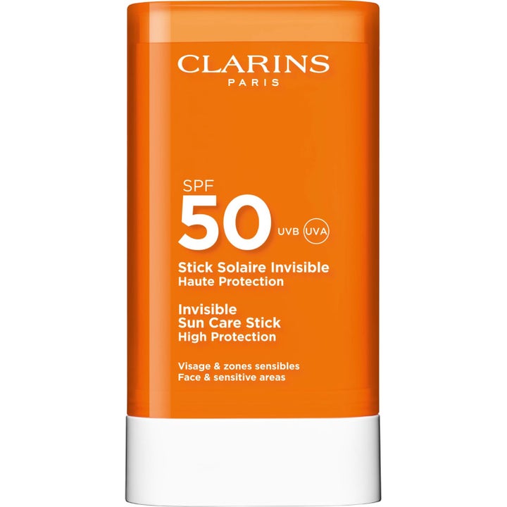Clarins Stick Solaire Invisible SPF 50 solskydd för ansiktet i en orange hylsa med vit bas och vit text