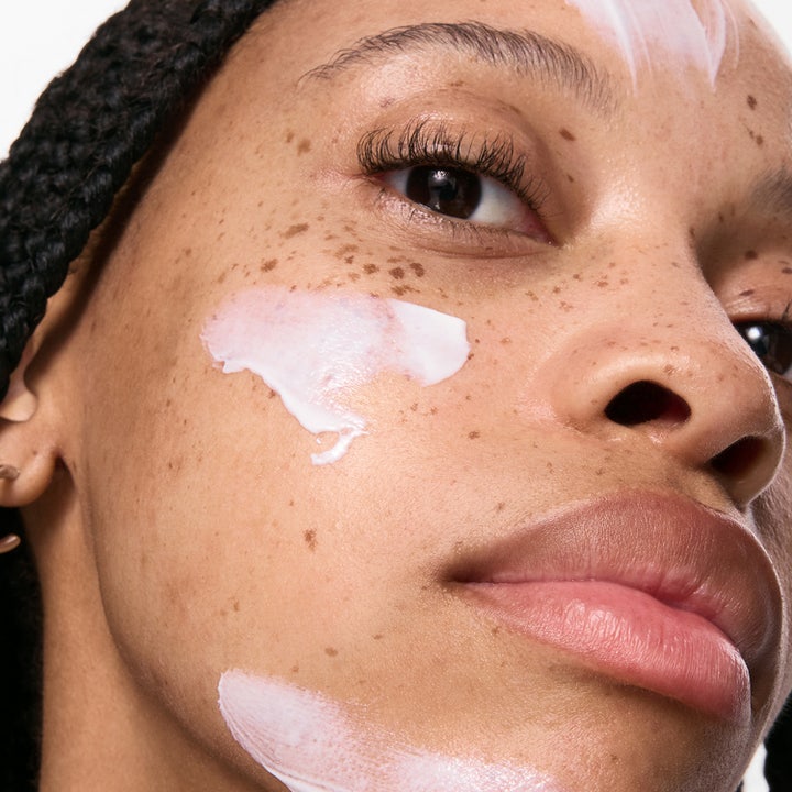 The INKEY List Polyglutamic Acid Dewy Sunscreen 50 ml återfuktande solkräm ger lyster ansikte på modell som håller tuben
