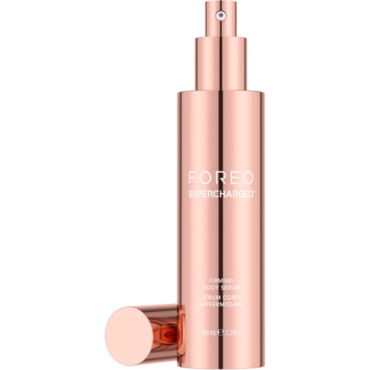 FOREO SUPERCHARGED Firming Body Serum 100 ml för huduppstramning i en glänsande roséguld pumpflaska med avtaget lock.