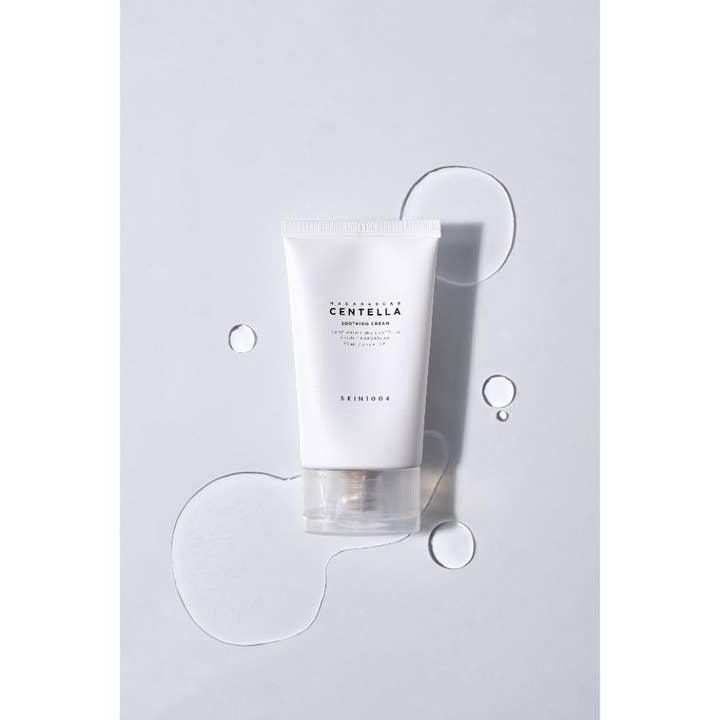 SKIN1004 Madagascar Centella Soothing Cream 75 ml lugnande centella dagkräm i vit tub omgiven av vattendroppar