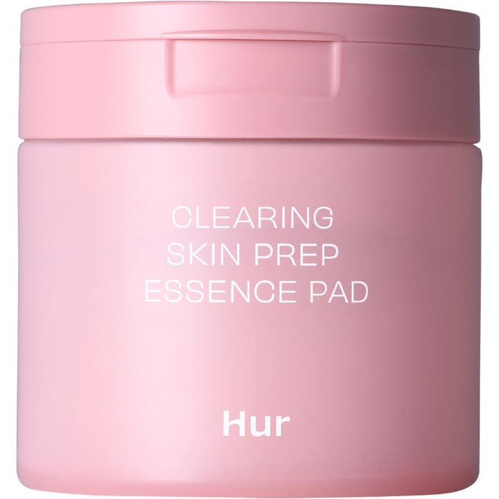 Hur Clearing Skin Prep Essence Pad rengörande ansiktspads i en matt rosa burk som ger en klar och förberedd hy.
