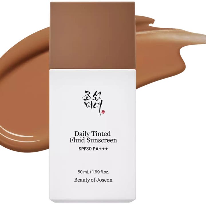 Beauty of Joseon Daily Tinted Fluid Sunscreen 50 ml tonad solkräm i vit flaska framför ett krämigt brunt färgprov