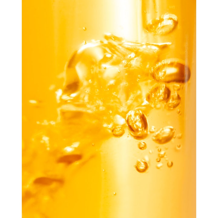 Nuxe Tanning Sun Oil 150 ml anti age sololja med högt skydd i en gyllene flytande textur med luftbubblor.