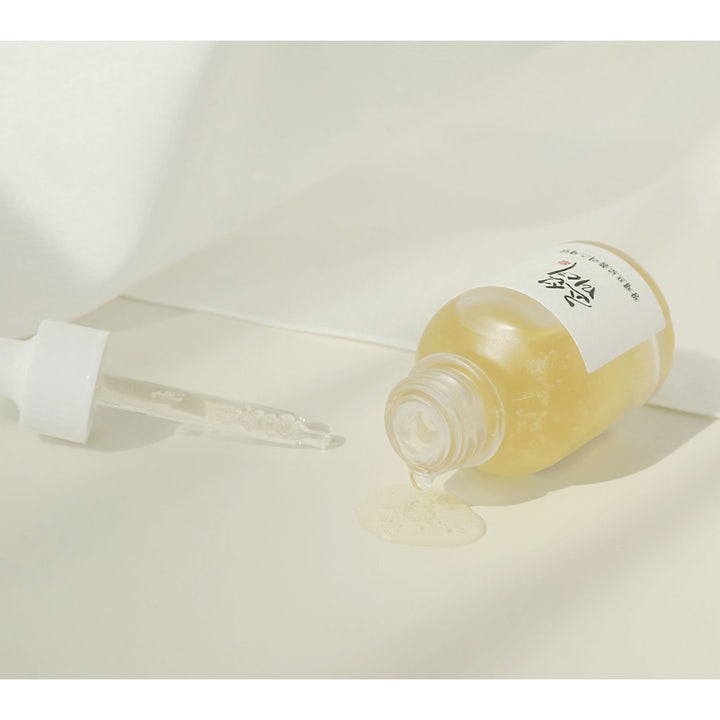 Beauty of Joseon Glow Serum 30ml lystergivande ansiktsserum med propolis som spills ur en liggande glasflaska.