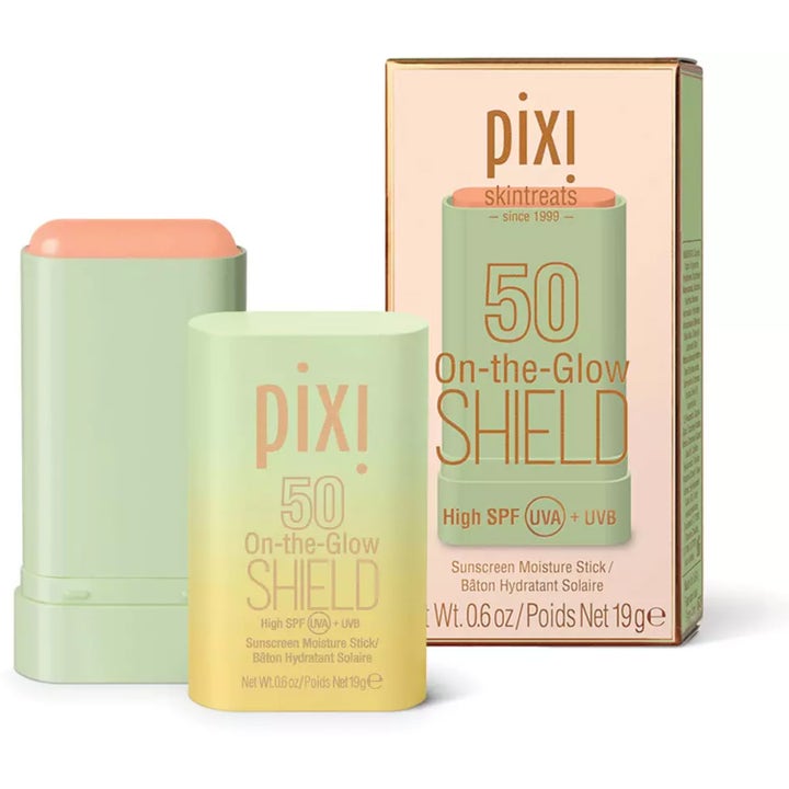 Pixi On-the-Glow Shield SPF 50 19 g solskyddsstift i grön hylsa bredvid sin persikofärgade ytterförpackning