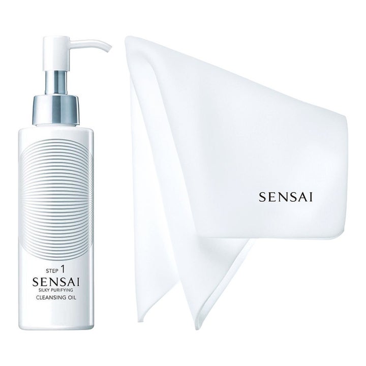 Sensai Silky Purifying Cleansing Oil Step 1 rengöringsolja för ansiktet i vit pumpflaska bredvid en vit rengöringsduk