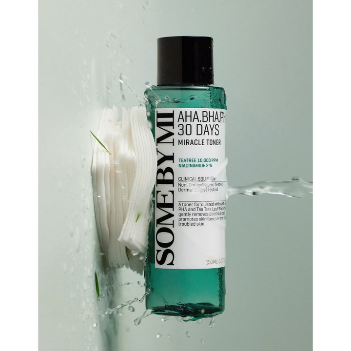 Some By Mi Aha-Bha-Pha 30 Days Miracle Toner 150 ml exfolierande toner i grön flaska bredvid vita bomullsrondeller och vatten