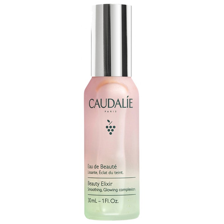 Caudalie Beauty Elixir 30 ml ansiktsspray för glansig hy ger lyster i en rosa och grön frostad flaska med silverkork