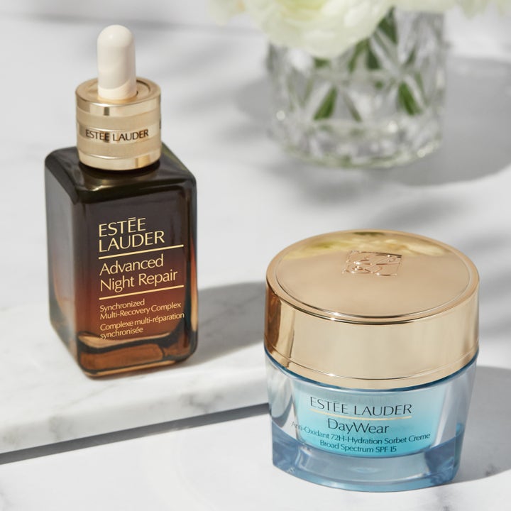 Estée Lauder DayWear 30 ml återfuktande dagkräm SPF 15 i blå glasburk bredvid Advanced Night Repair serum på marmor.