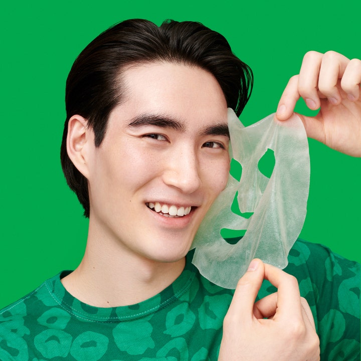 Dr.Jart+ Cicapair Intensive Soothing Repair Serum Mask 25 g cica återfuktande ansiktsmask som hålls upp av en leende man.