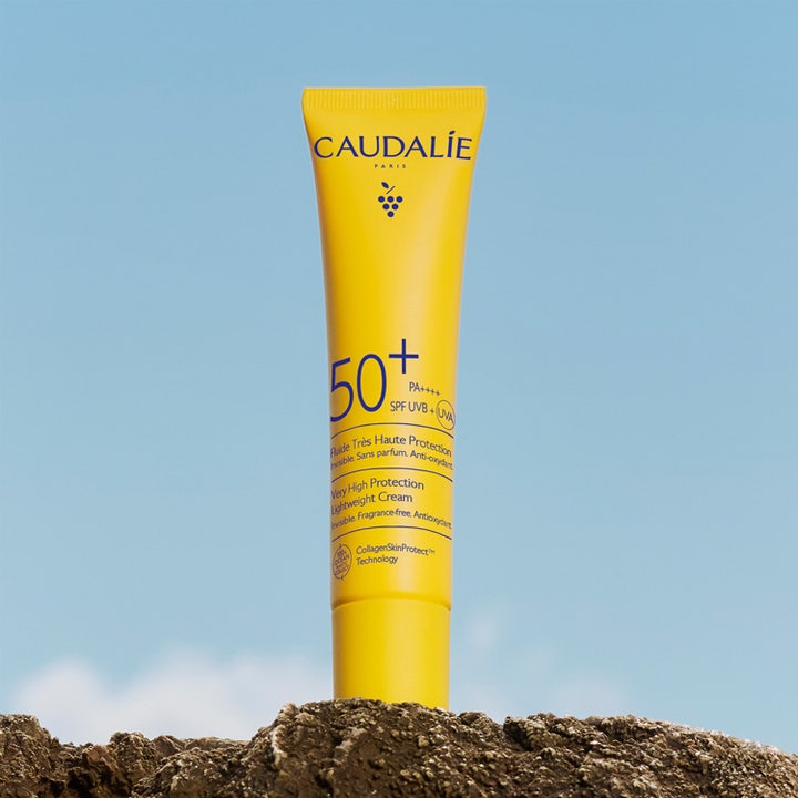 Caudalie Vinosun Very High Protection Lightweight Fluid SPF50 40 ml ger solskydd i gul tub mot blå himmel.