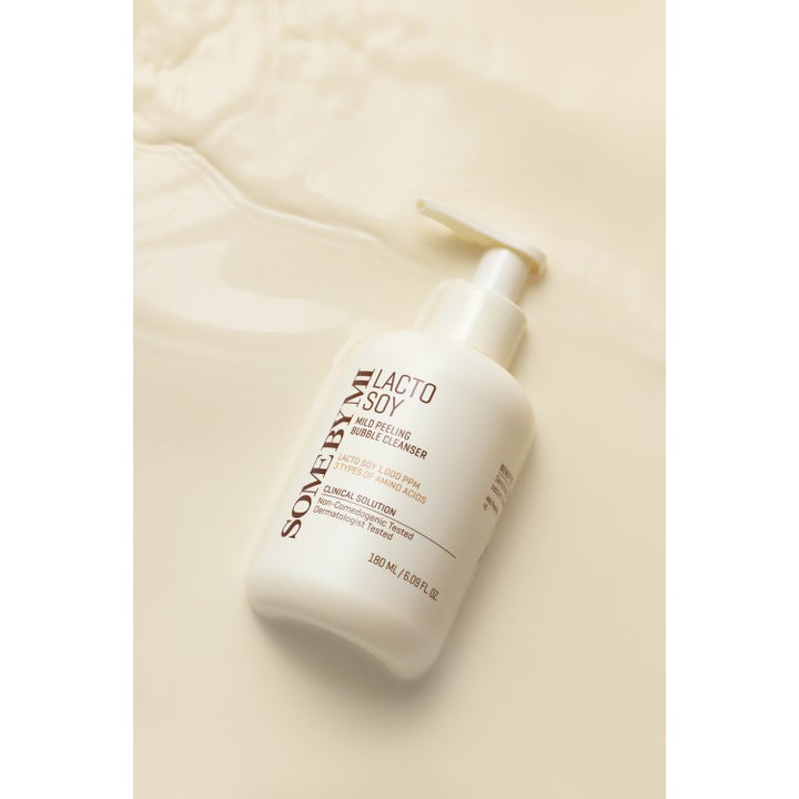 Some By Mi Lactosoy Mild Bubble Peeling Cleanser 180 ml aminosyra ansiktspeeling i vit pumpflaska på mjölkig textur.