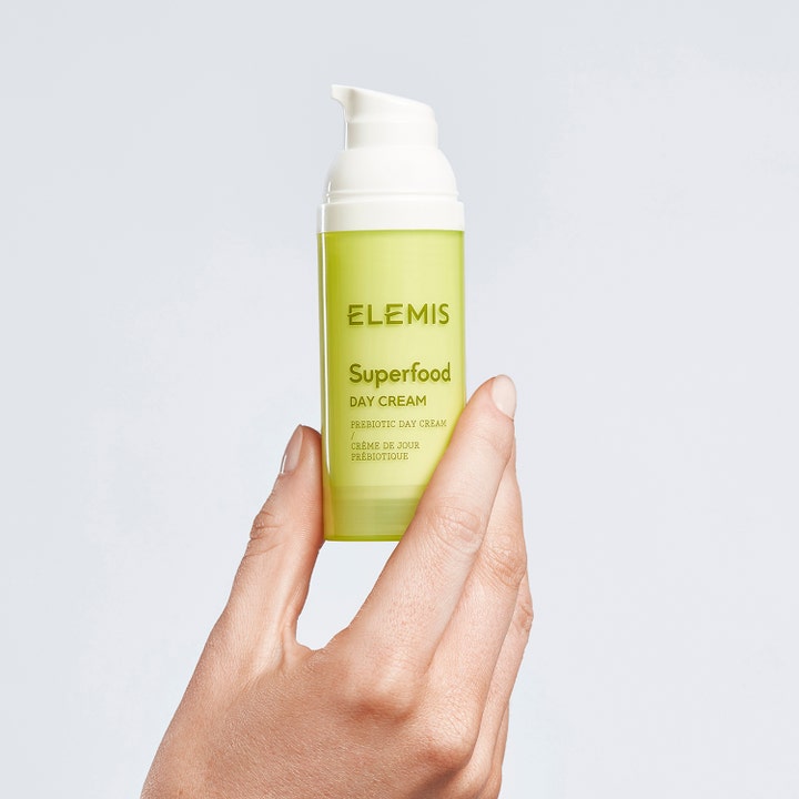 Elemis Superfood Day Cream 50 ml återfuktande dagkräm i en limegrön pumpflaska som hålls i en hand.