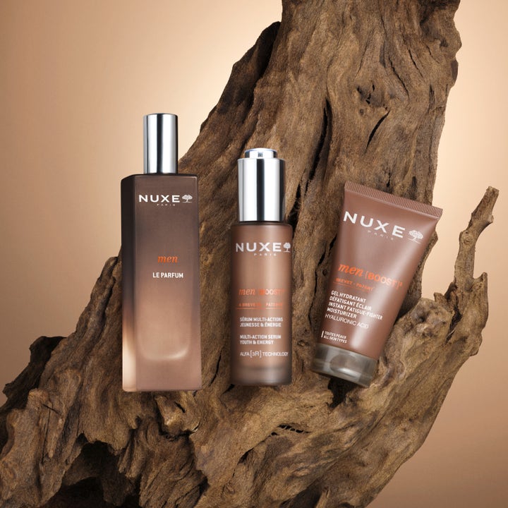 Nuxe Men Multi Action Serum 30 ml mot rynkor i brun glasflaska framför dekorativt trä.