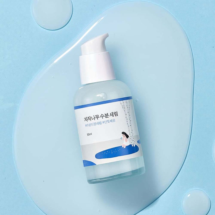 Round Lab Birch Juice Moisturizing Serum 50 ml återfuktande björksaft serum i pumpflaska på ljusblå vattenyta.