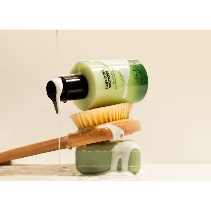 haruharu wonder Black Bamboo Daily Smoothing Body Oil 200 ml återfuktande kroppsolja på en träborste med mjölkig textur