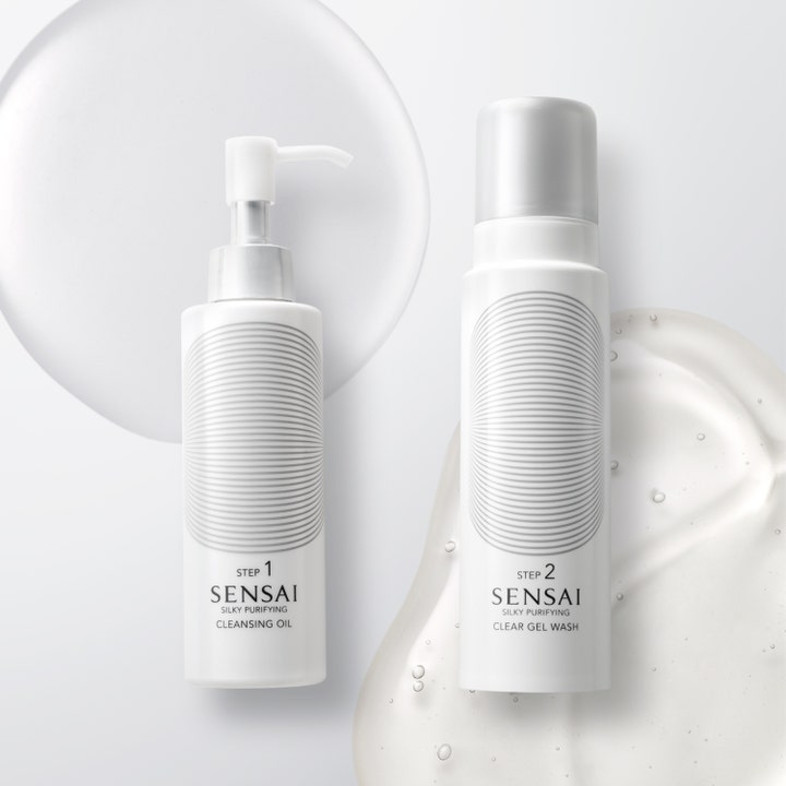 Sensai Silky Purifying Clear Gel Wash 145 ml clear gel ansiktstvätt i vita flaskor omgivna av bubblig geltextur.