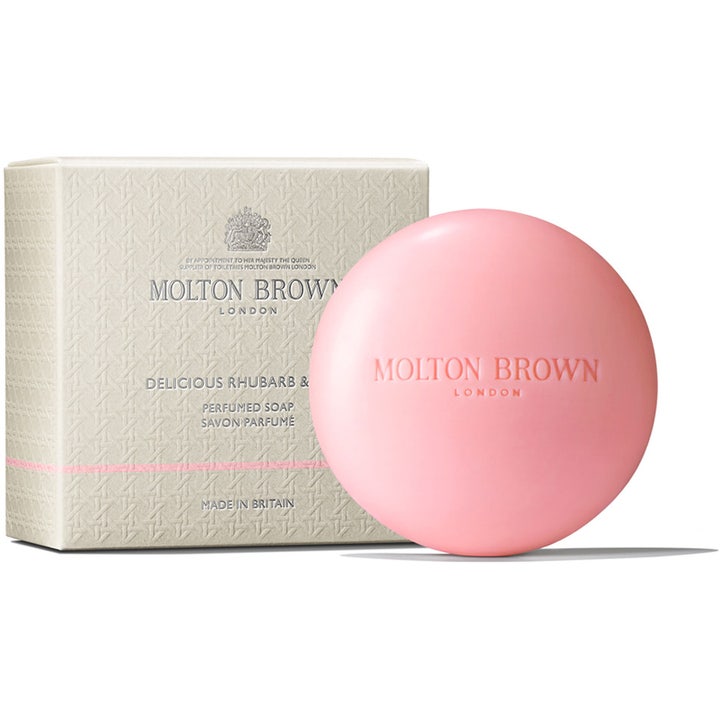 Molton Brown Delicious Rhubarb & Rose 150 g parfymtvål är en rund rosa handtvål med en elegant mönstrad krämfärgad ask.