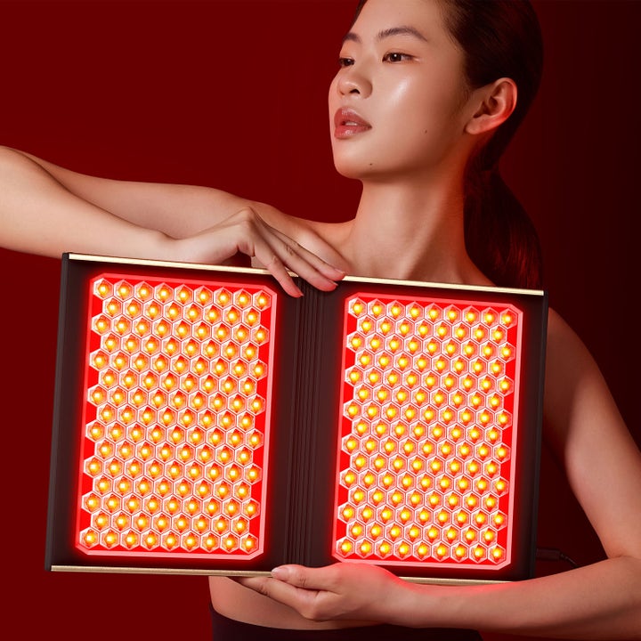FAQ Swiss FAQ™ Dual Led Panel 1 st hudvårdsverktyg kvinna som håller i en utfällbar panel med röda LED-lampor.