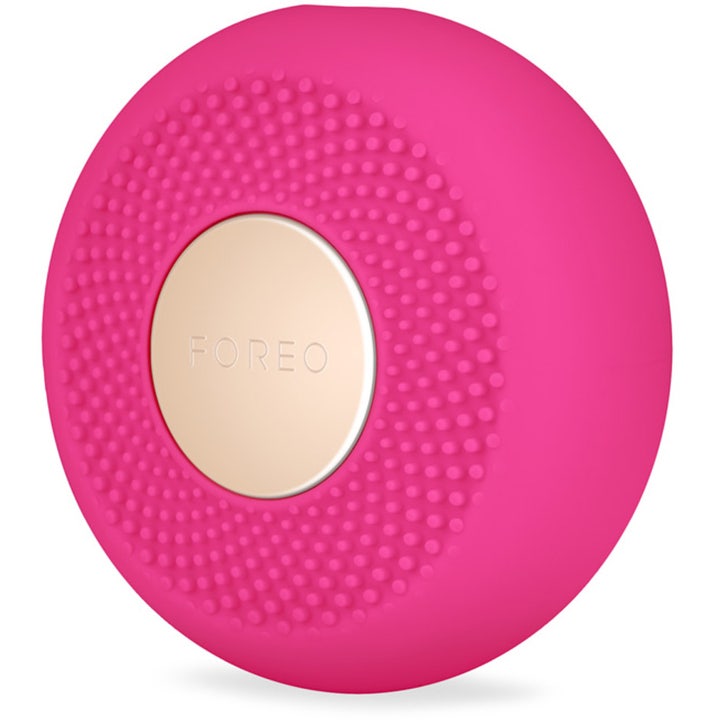 FOREO UFO mini 2 Fuchsia led ljusterapi ansikte apparat i fuchsia silikon med en rund guldfärgad platta.