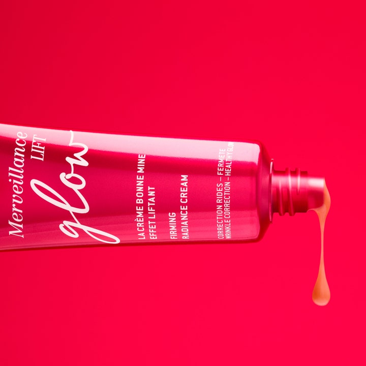 Nuxe Merveillance Lift Glow 50 ml uppstramande kräm ansikte med persikofärgad formula som droppar ur en rosa tub