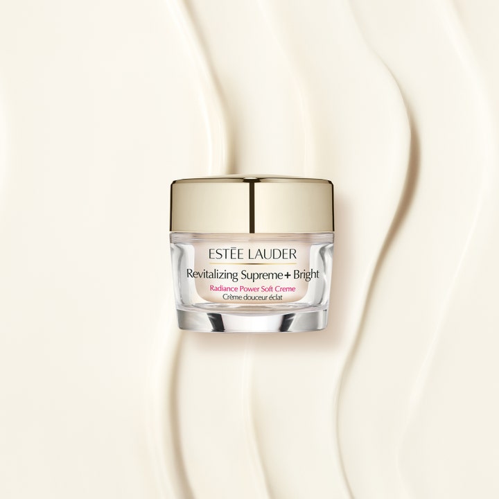 Estée Lauder Revitalizing Supreme+ Bright 50 ml dagkräm med lyster i glasburk med guldlock mot vågig krämig textur