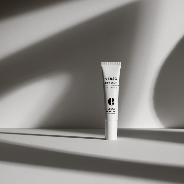 Verso N°9 Lip Serum 15 ml föryngrande läppserum med retinol 8 i vit tub i en miljö med konstnärliga skuggor