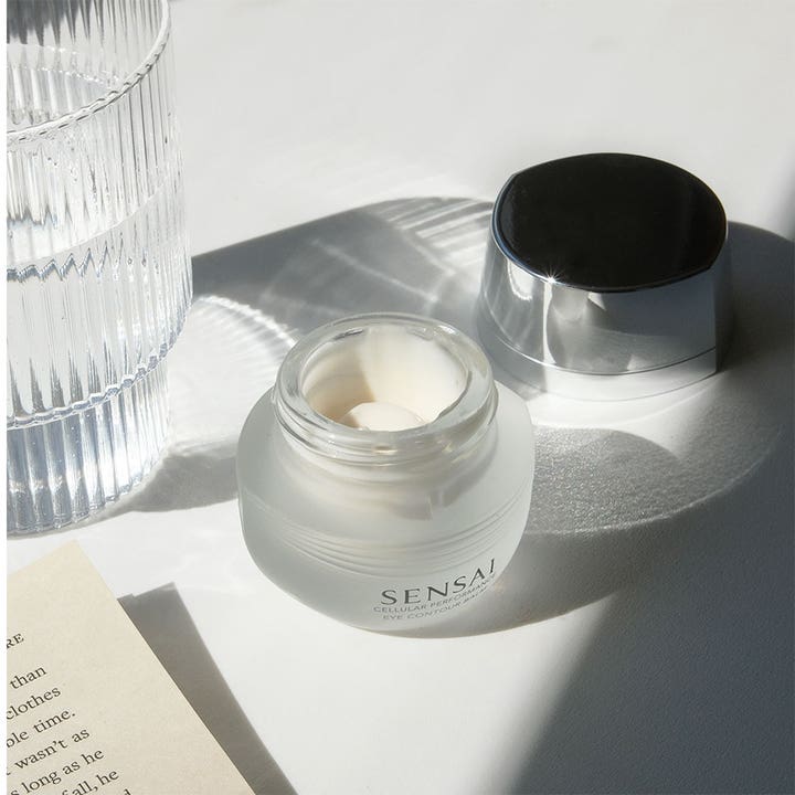 Sensai Cellular Performance Eye Contour Cream 15 ml återfuktande ögonkräm i öppen burk av frostat glas med vit kräm.