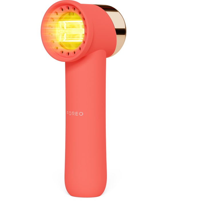 Foreo Peach 2 IPL för effektiv hårborttagning i korallfärgad design med guldiga detaljer och lysande gult fönster