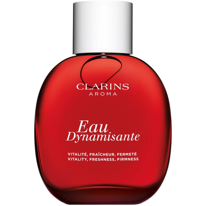 Clarins Eau Dynamisante 100 ml uppiggande fragrance spray i en rund röd glasflaska med silverfärgat lock