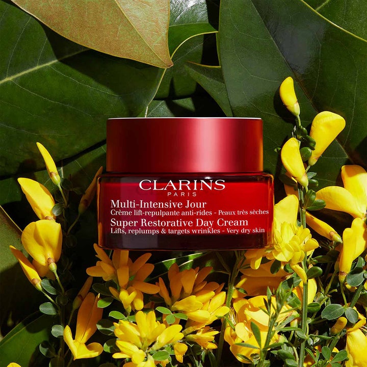 Clarins Super Restorative Day Cream 50 ml intensivt återfuktande dagkräm omgiven av gula blommor