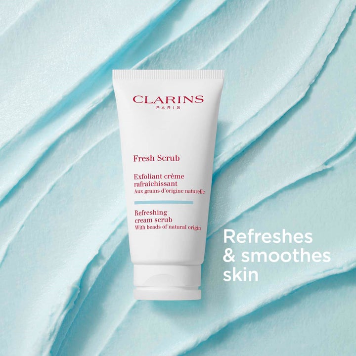 Clarins Fresh Scrub Refreshing Cream Scrub 50 ml ansiktspeeling i vit tub på krämig ljusblå textur.