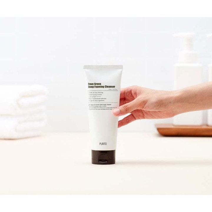 Purito From Green Deep Foaming Cleanser 150 ml skonsam rengöring i vit tub med svart lock som hålls i en hand.