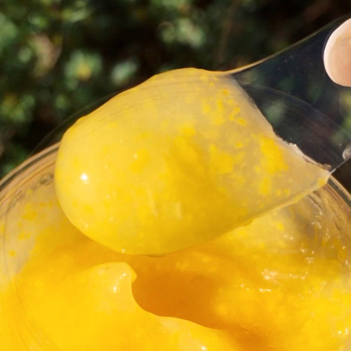 Saturday Skin Yuzu Vitamin C Sleep Mask 50 ml nattmask med vitamin C och gul gelkonsistens med korn på en spatel