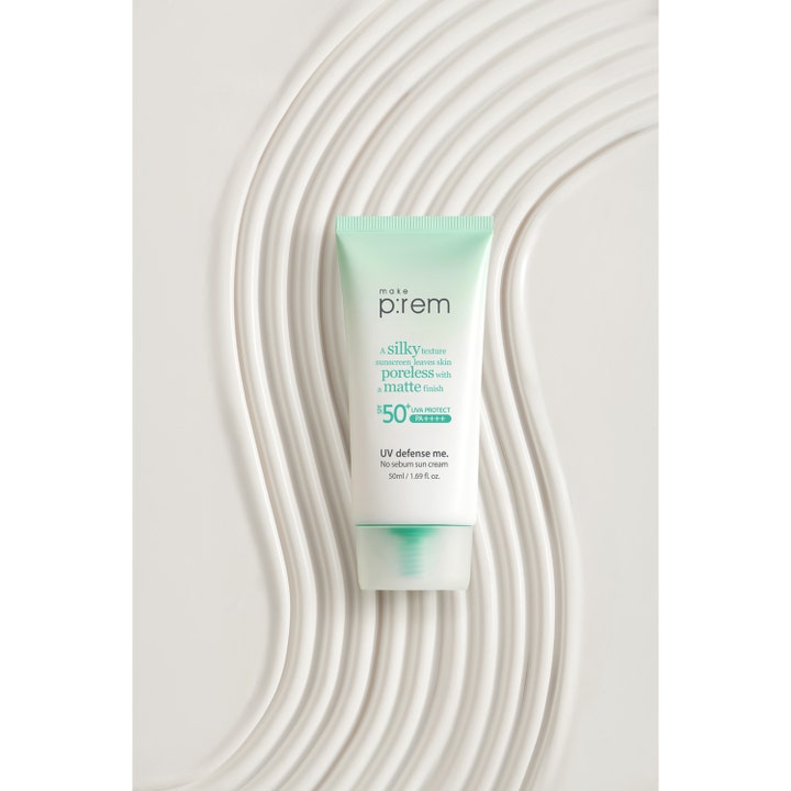 Make Prem No Sebum Sun Cream 50 ml koreansk solkräm matt finish SPF 50 i vit och mintgrön tub på vågig bakgrund.