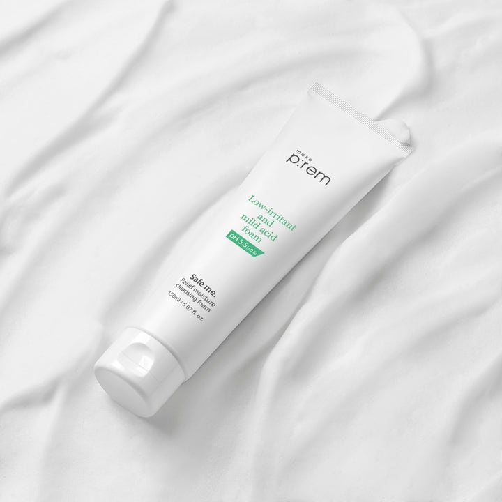 Make Prem Safe Me Relief Moisture Cleansing Foam 150 ml milt pH 5.5 rengöringsskum i vit tub på vitt vågigt tyg.