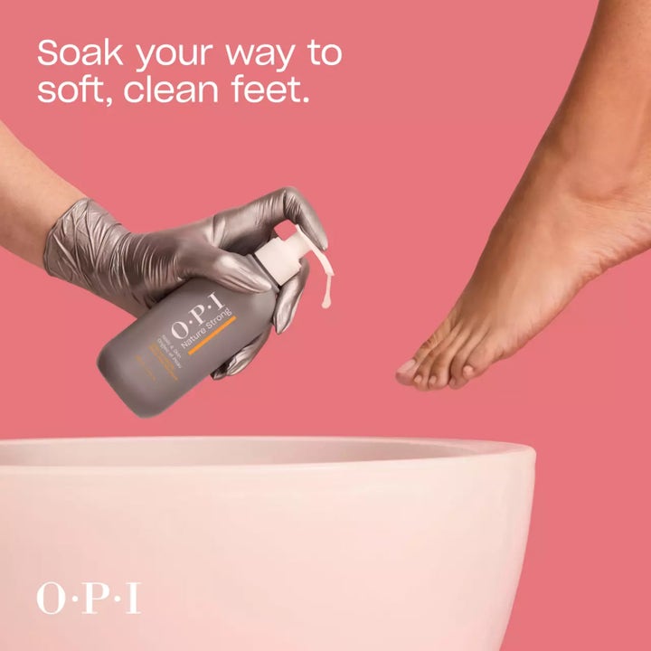 OPI Nature Strong Soften Up Pedi Soak 250 ml mjukgörande fotbad i grå pumpflaska som hälls i vitt kar