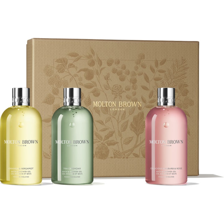 Molton Brown Bath & Shower Gel 3x300ml presentask med färgglada flaskor framför en guldfärgad mönstrad ask