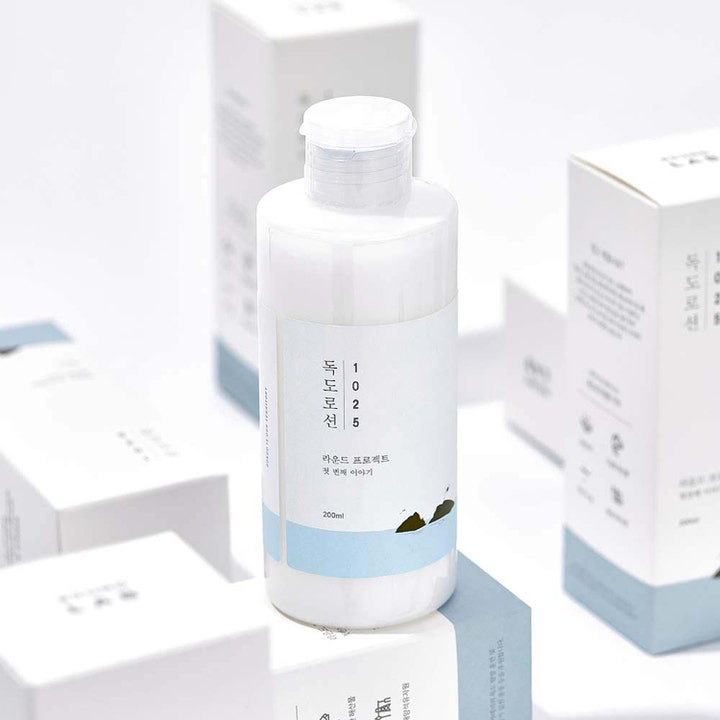 Round Lab 1025 Dokdo Lotion 200 ml återfuktande ansiktslotion i vit flaska omgiven av matchande ytterförpackningar.