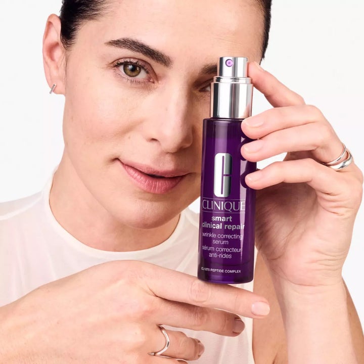 Clinique Smart Clinical Repair Wrinkle Correcting Serum 75 ml mot rynkor i lila pumpflaska som hålls av en kvinna