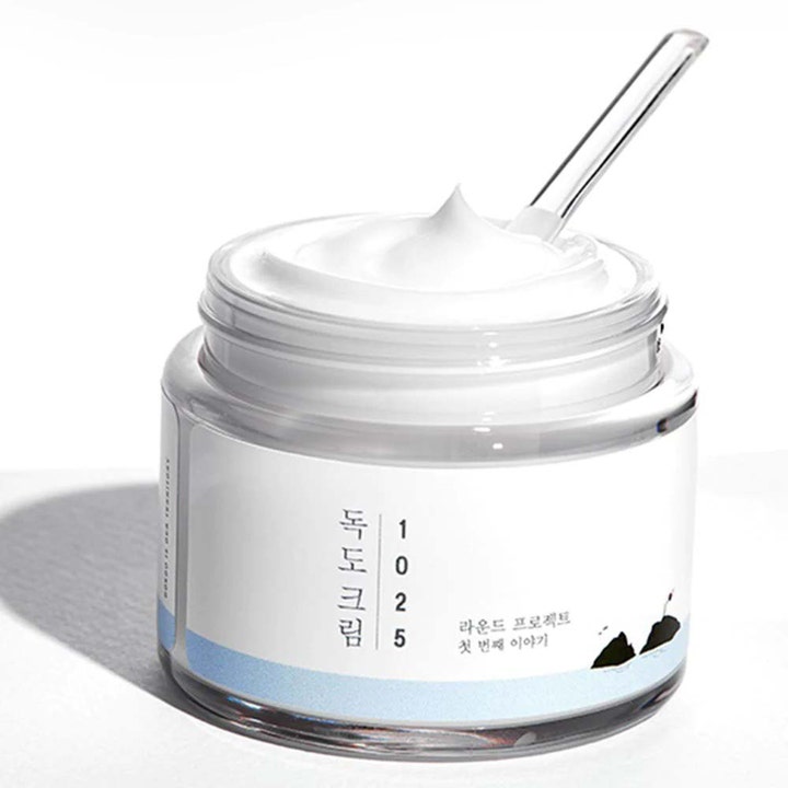 Round Lab 1025 Dokdo Cream 80 ml återfuktande k-beauty fuktkräm ansikte med vit krämig textur i glasburk och spatel