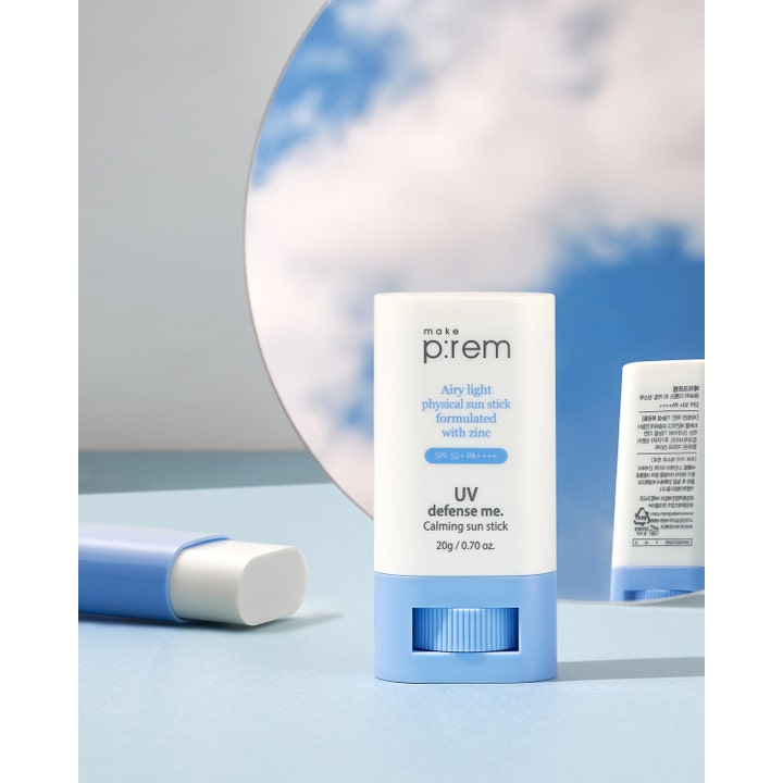 Make Prem UV Defense Me Calming Sun Stick 20 g lugnande solstift med zink framför en spegel som reflekterar blå himmel.