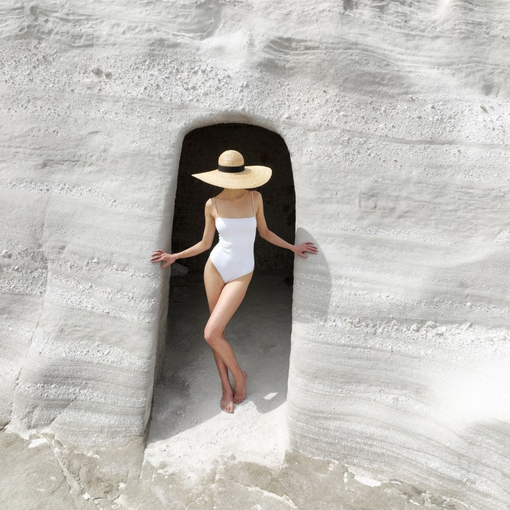 KORRES Yoghurt Tinted Sunscreen Face Cream 50 ml tonad solkräm ansikte spf 30 med kvinna i solhatt vid vit stengrotta