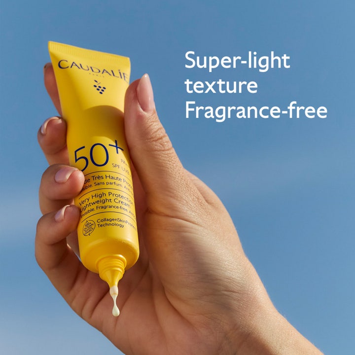 Caudalie Vinosun SPF 50 40 ml oparfymerad solkräm med lätt konsistens som droppar från en gul tub mot blå himmel.