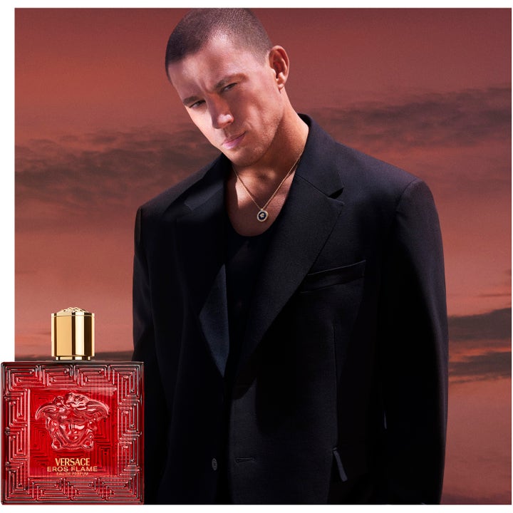 Versace Eros Flame 100 ml deospray herr daglig användning visar röd glasflaska och en man i svart kavaj vid solnedgång.