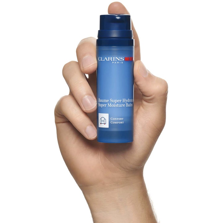 Clarins Men Super Moisture Balm 50 ml återfuktande ansiktskräm i blå pumpflaska märkt Confort som hålls i en hand.