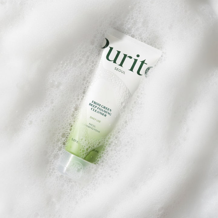 Purito From Green Deep Foaming Cleanser 150 ml skonsam rengöring i vit tub med svart lock som hålls i en hand.