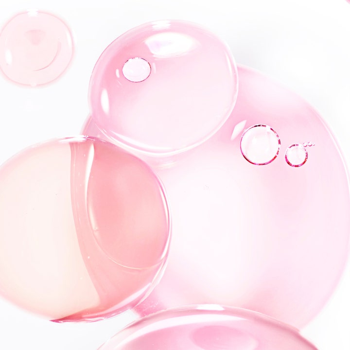 Lancôme Hydra Zen Anti-Stress 50 ml återfuktande ansiktskräm med en textur av rosa transparenta bubblor och droppar.
