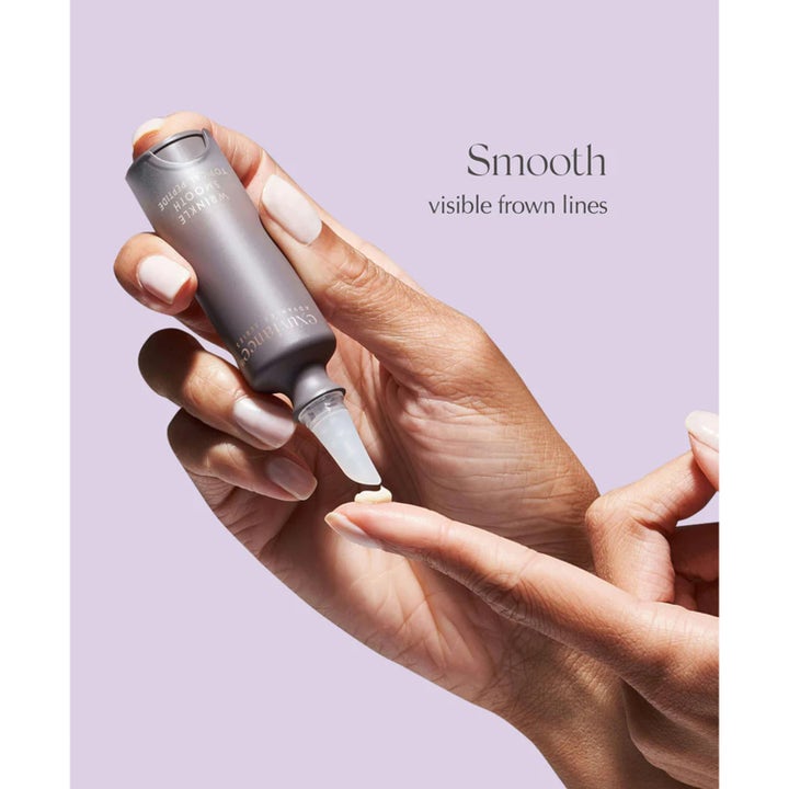 Exuviance Wrinkle Smooth Topical Peptide 5 g rynkreducerande serum där en hand applicerar krämig textur från en grå tub.