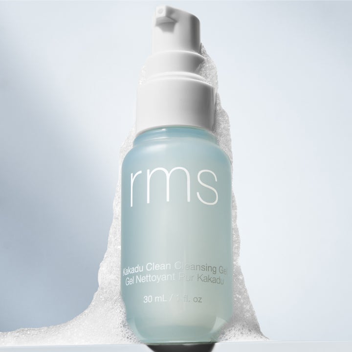 RMS Beauty Kakadu Clean Cleansing Gel 30 ml rengöringsgel i frostad blå pumpflaska omgiven av vitt luftigt skum.
